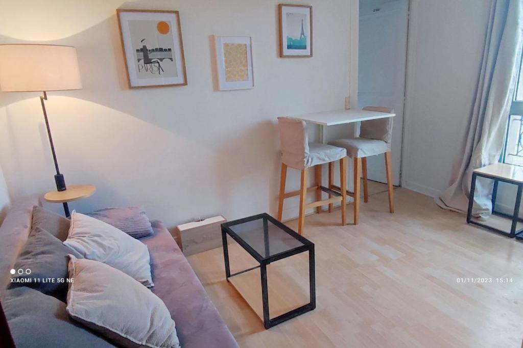 Le Pré-Saint-GervaisAppartement Cosy à 10min de la Villette & du Philharmonie Paris的客厅配有沙发和桌子