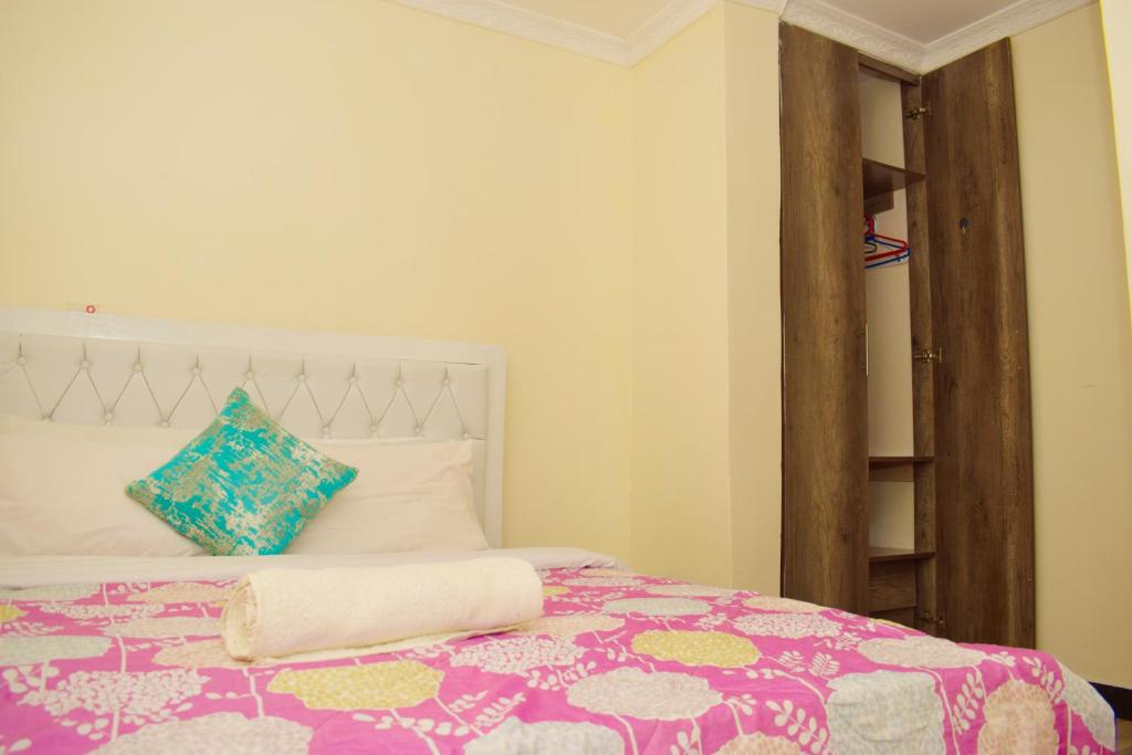 ThikaFully furnished one bedroom in Thika Cbd的一间卧室配有一张带彩色毯子的床