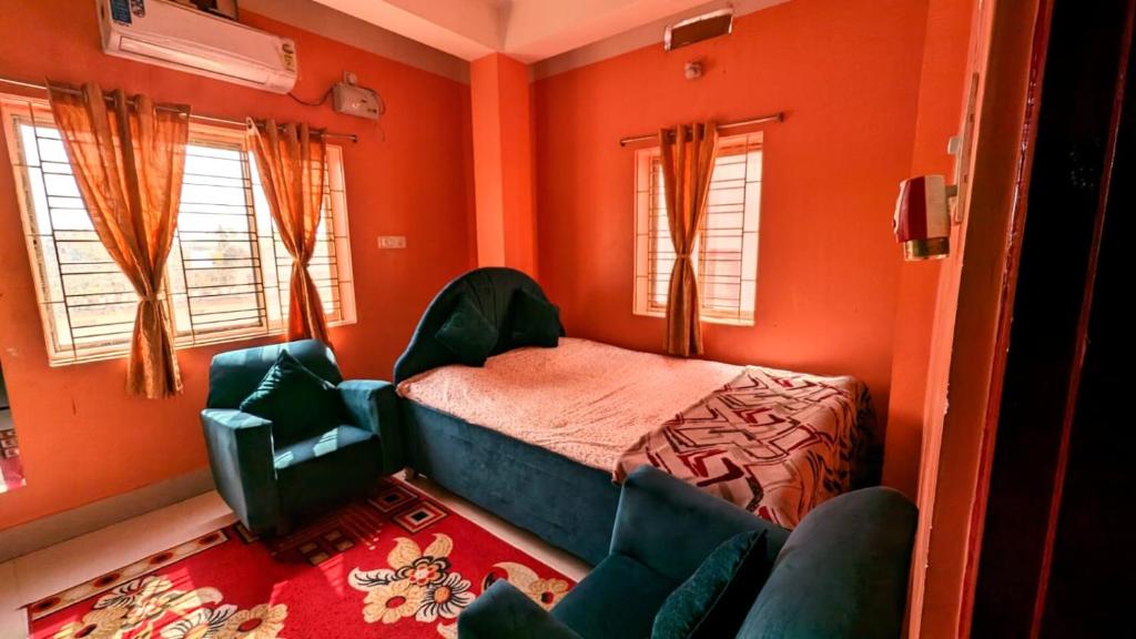 阿加尔塔拉Veda Homestay的一间卧室拥有橙色的墙壁,配有一张床和椅子