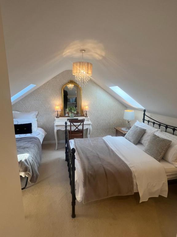 科舍姆Highcroft House的一间卧室配有两张床和镜子