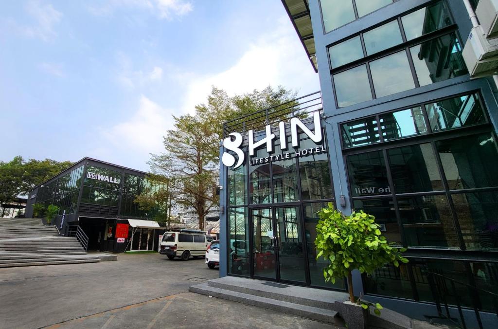清迈SHIN Hotel Nimman ChiangMai的建筑前有标志的商店