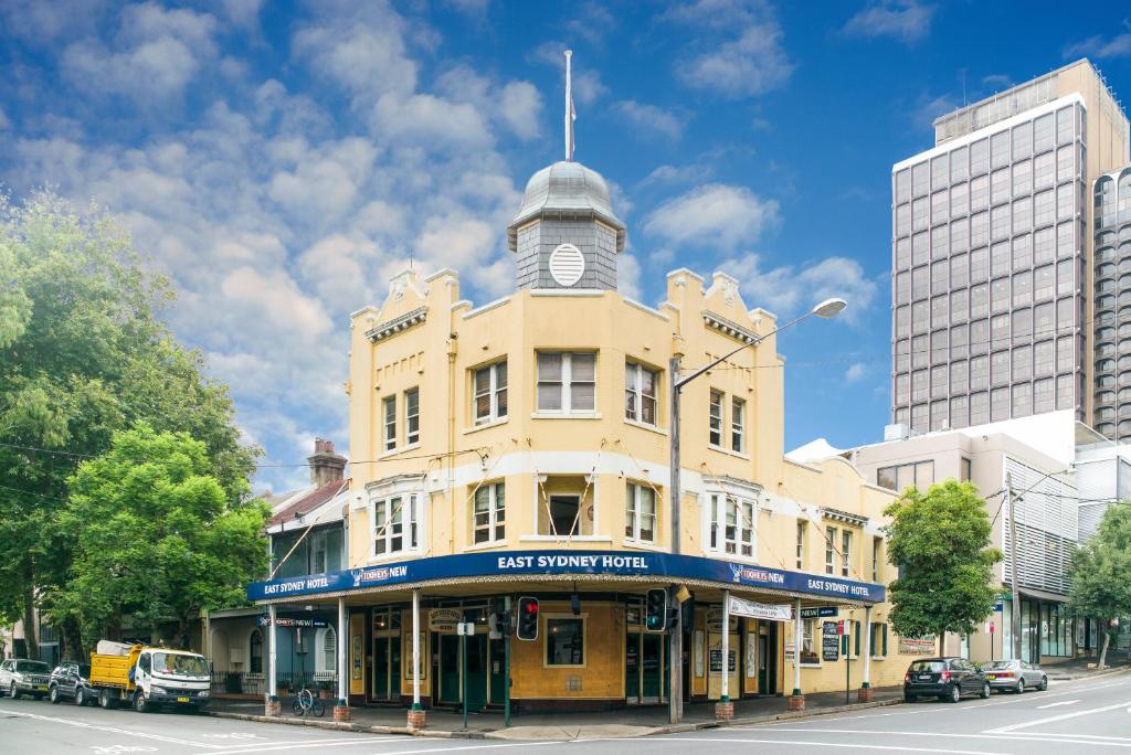 悉尼东悉尼酒店的街上一座黄色的建筑,有钟楼