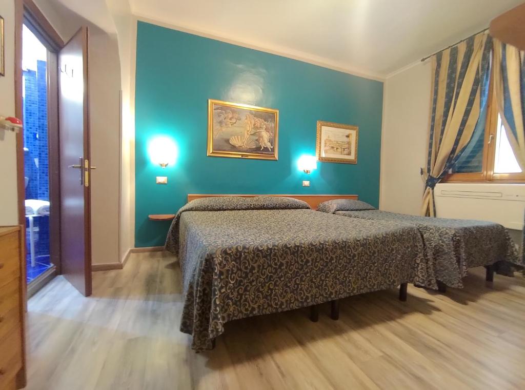 佛罗伦萨桑塔克罗奇酒店的蓝色墙壁客房的两张床