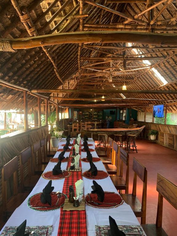 卡拉图Patamu Restaurant & Lodge的一张长桌,上面坐着黑鸟