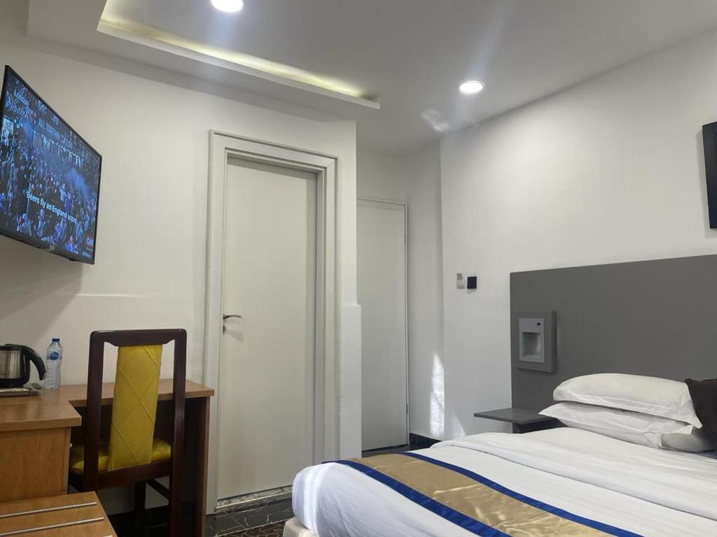 阿布贾Hotel 5092的一间卧室配有一张床、一张书桌和一个窗户。