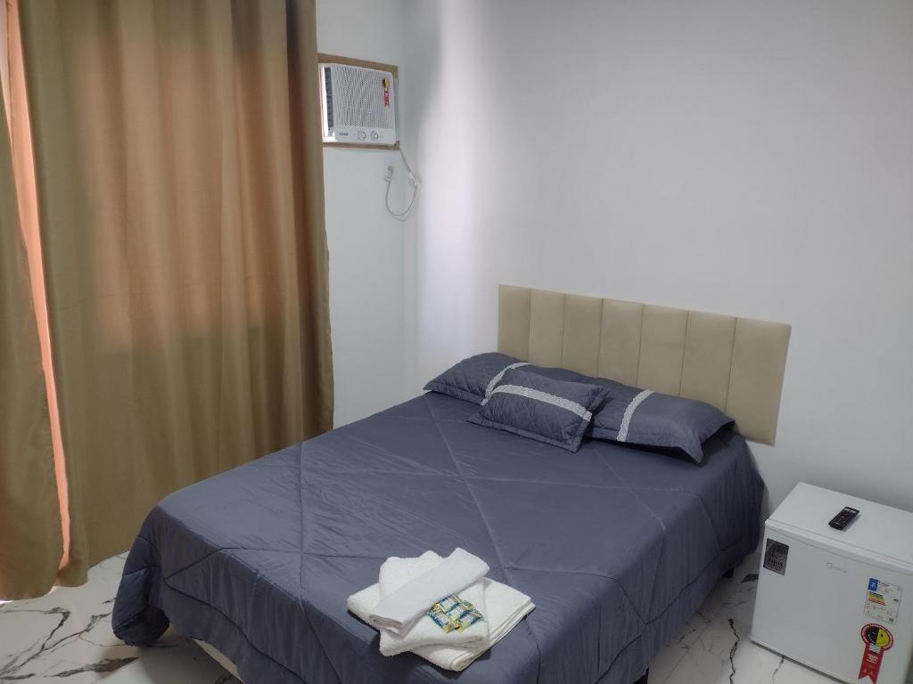 萨夸雷马top Suites的一间卧室配有一张带蓝色床单和蓝色枕头的床。
