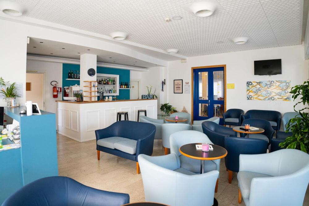 切塞纳蒂科欧亨尼奥酒店的一间设有蓝色椅子和桌子的等候室