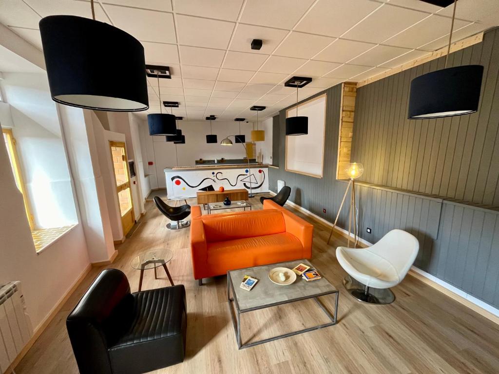 米耶雷斯The Orange Teddy Bear Hostels La Peña的客厅配有橙色沙发和椅子