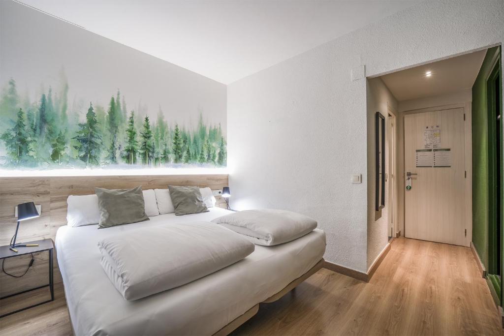 安道尔城Glaner Hotel Cafe的一间卧室设有一张床和一个树木繁茂的窗户