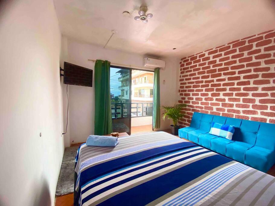 蒙塔尼塔Suite céntrico vista al Mar的一间卧室设有蓝色的沙发和砖墙