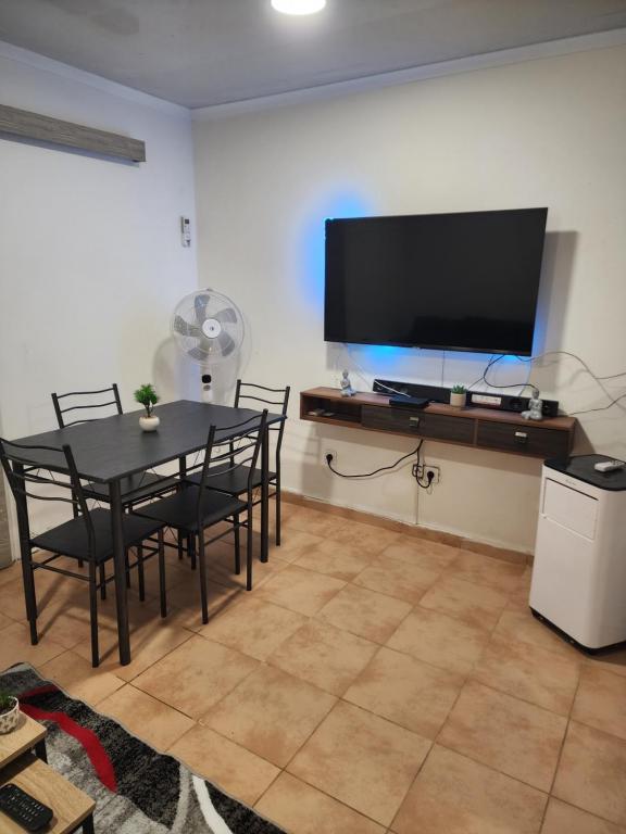 Rio do OuroMaria的一间带桌子和平面电视的用餐室
