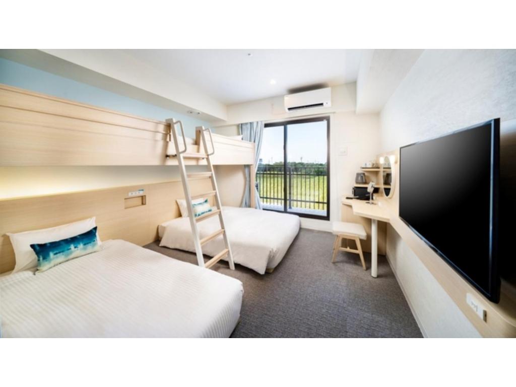宫古岛Hotel Torifito Miyakojima Resort - Vacation STAY 79480v的酒店客房配有双层床和电视。