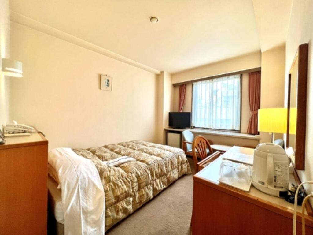 千叶Hotel Tetora Makuhari Inagekaigan - Vacation STAY 90828v的配有一张床和一张书桌的酒店客房