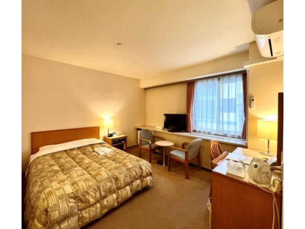 千叶Hotel Tetora Makuhari Inagekaigan - Vacation STAY 91509v的配有一张床和一张书桌的酒店客房