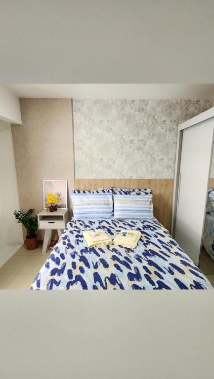 巴西利亚Confortável Studio no Park Sul próximo ao aeroporto的一间卧室配有一张带蓝色和白色棉被的床