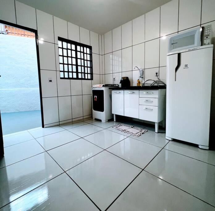 大坎普Casa privativa próximo ao centro e aeroporto.的厨房配有白色家电和白色冰箱