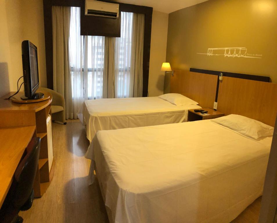 巴西利亚Flat 609 - Comfort Hotel Taguatinga的酒店客房设有两张床和一台平面电视。