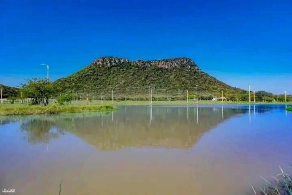 巴拉瓜里Cabaña “La Herencia” Paraguarí的坐在一大片水面上的山