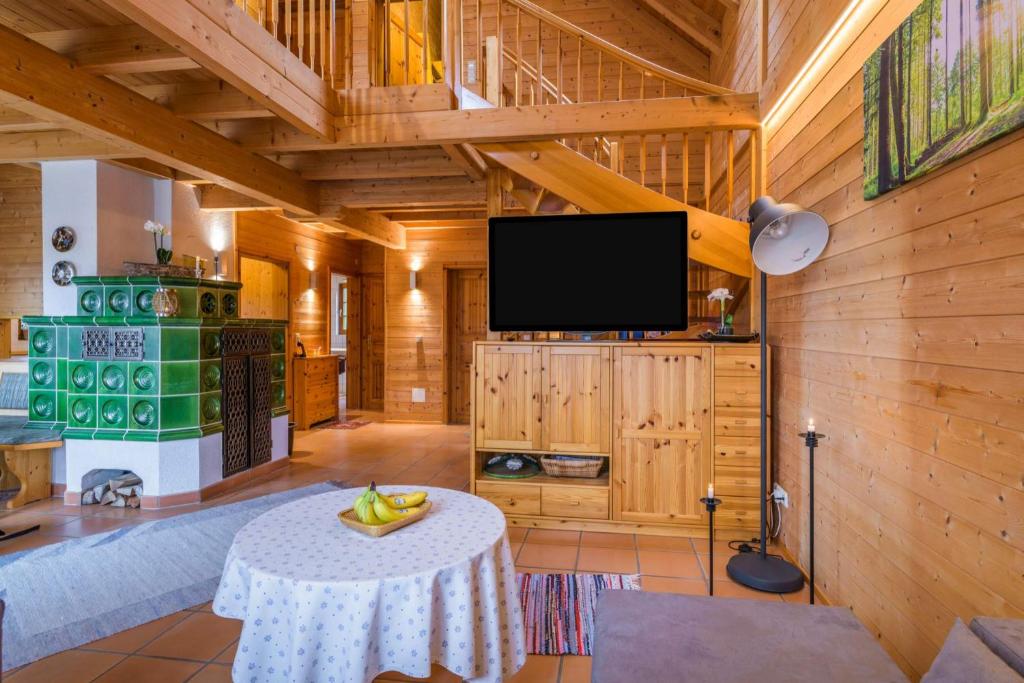 Holzhaus Oberbrändi的客厅配有桌子和平面电视。