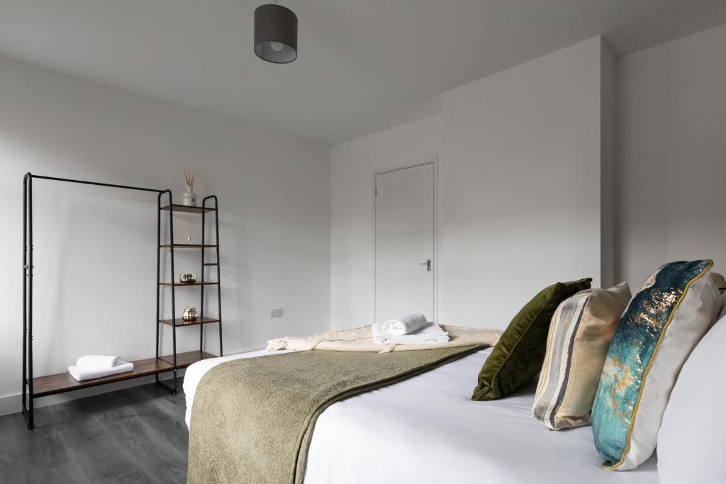 科尔切斯特Sunbeam cottage contractor Parking WiFi Garden的卧室拥有白色的墙壁,配有带枕头的床铺。