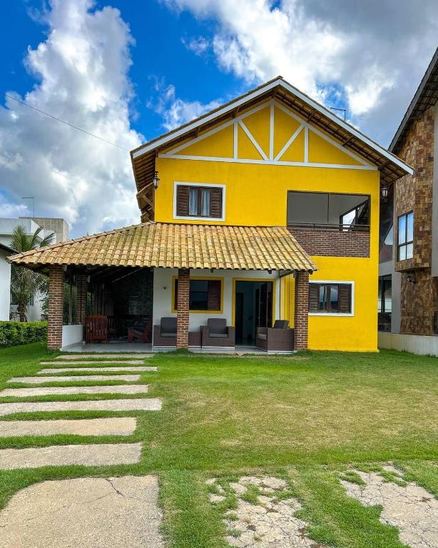 巴纳内拉斯Casa em Bananeiras PB的一座黄色房子,有草地庭院