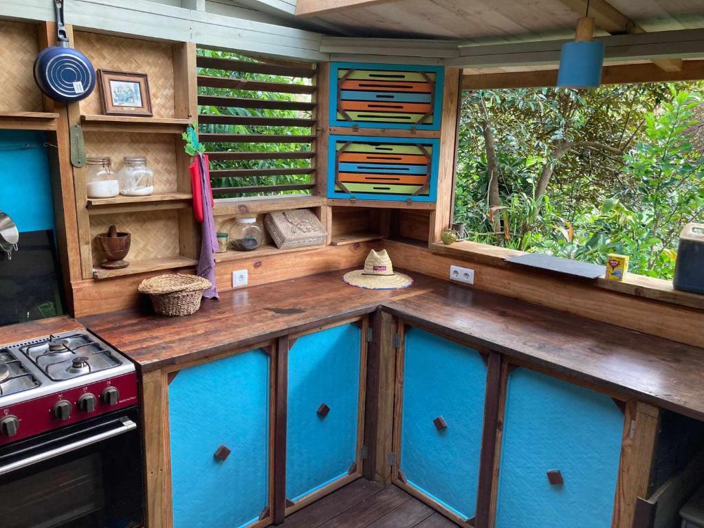 PaïtaLa pirogue enchantée的一间配备有蓝色橱柜和炉灶的户外厨房