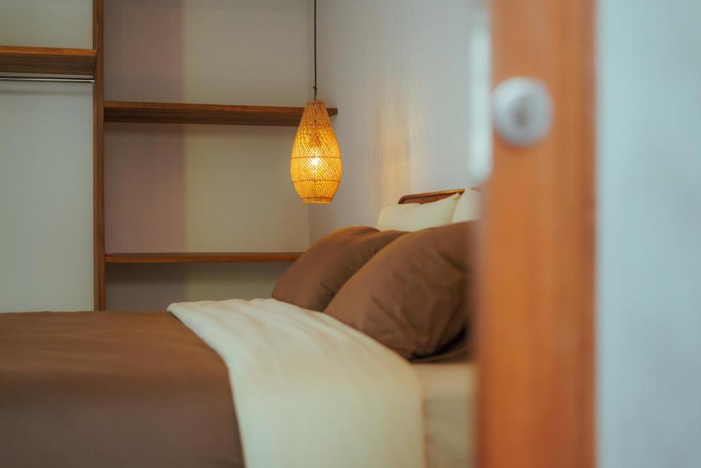 龙目岛库塔Karyana Apartment的一间卧室配有床和灯具