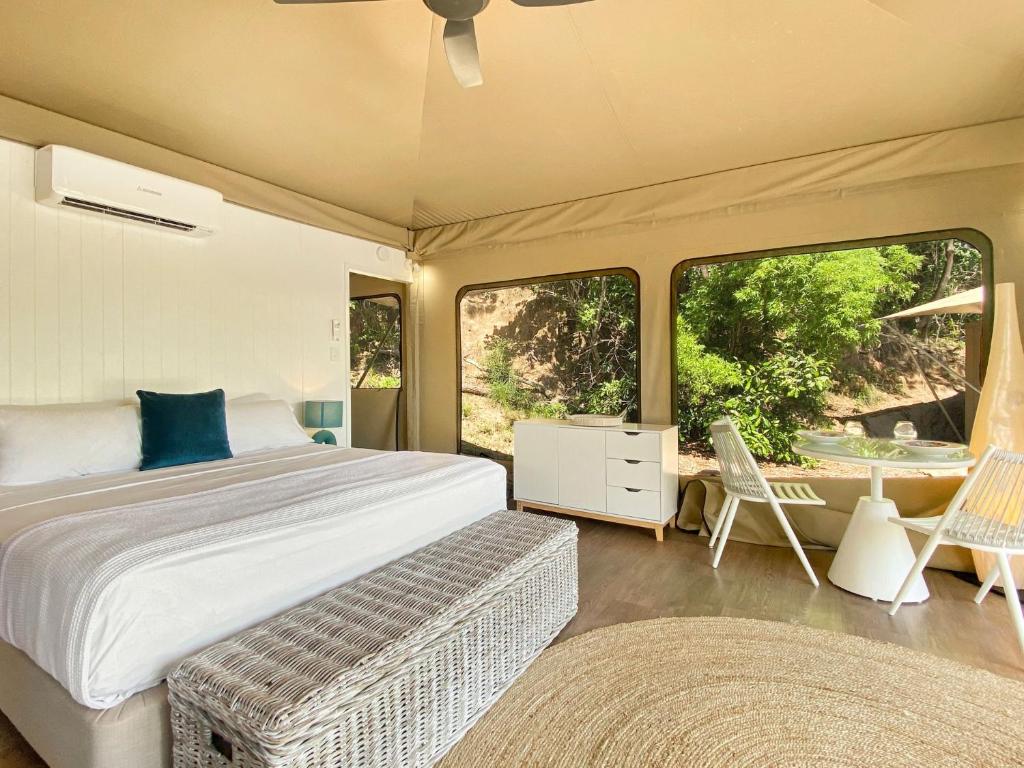 耐莉湾Magnetic Glamping Tent 3的卧室配有一张床和一张桌子及椅子
