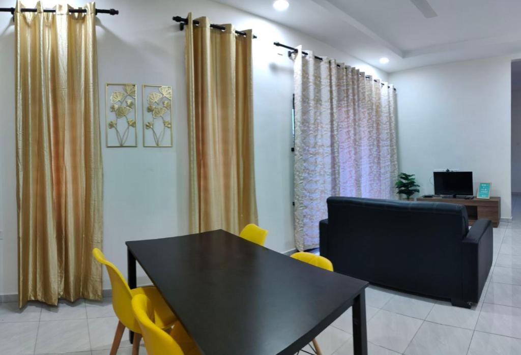 Kepala BatasHomestay HABI Residence的一间用餐室,配有一张黑桌子和黄色椅子