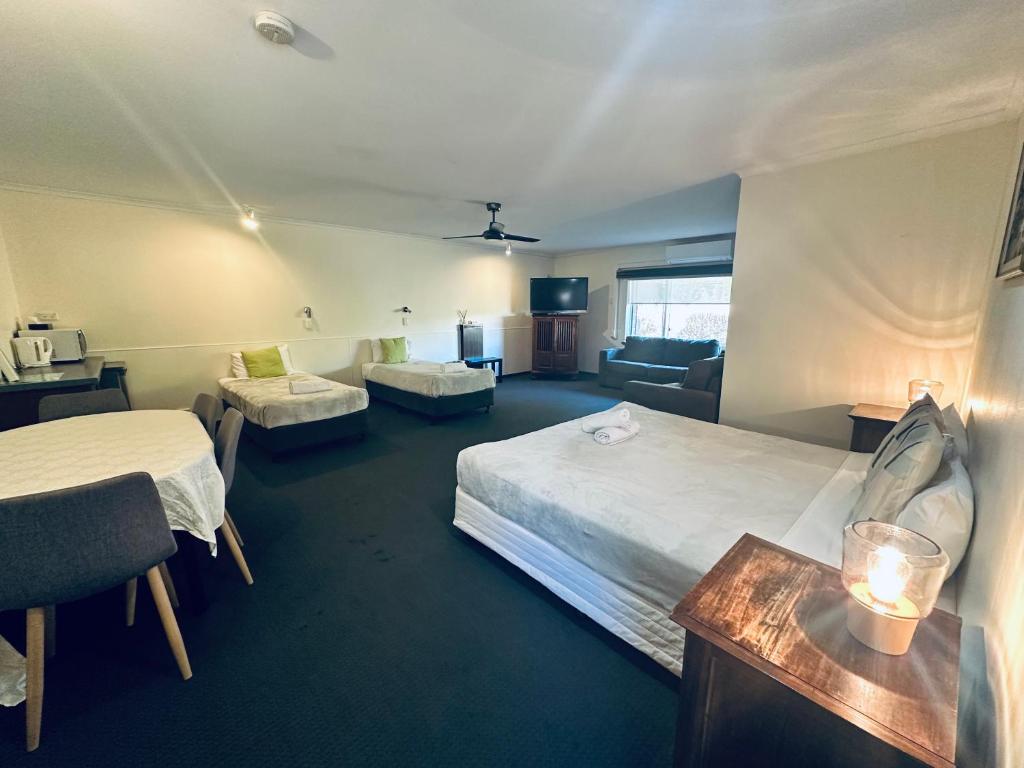 长滩港Beachport Motor Inn的酒店客房设有一张大床和一张沙发。