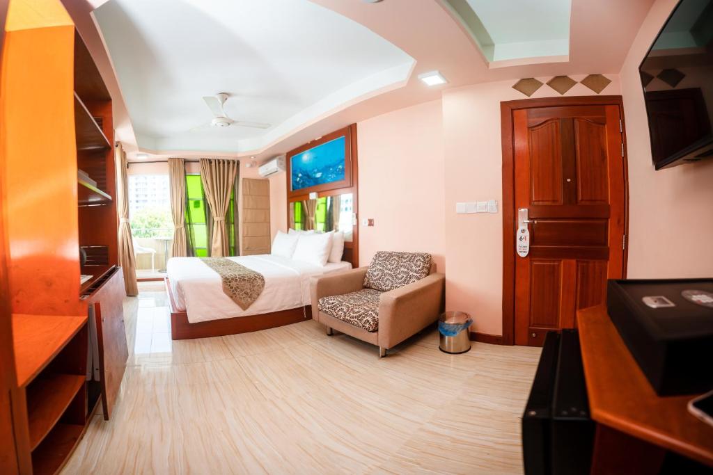 马累ZAN Lodge的配有一张床和一把椅子的酒店客房