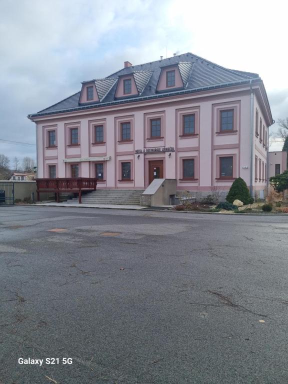 RaspenavaHotel Zámeček Raspenava的黑色屋顶的大型粉红色建筑