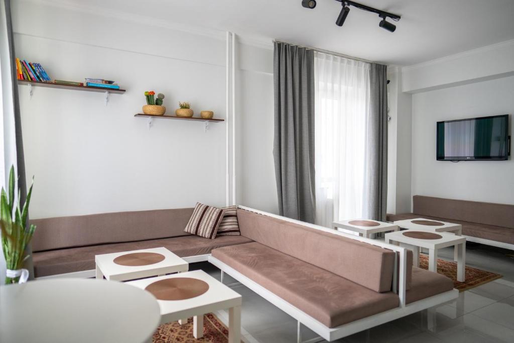 乌兰巴托扎亚旅馆的客厅配有沙发、桌子和电视