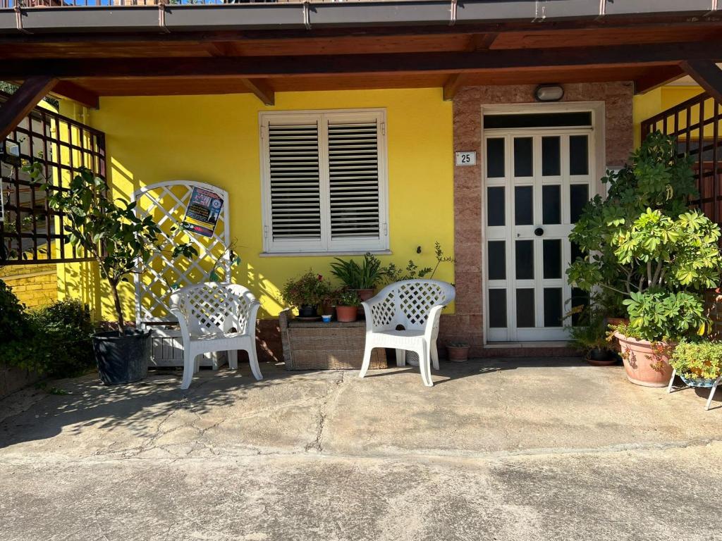 日帕特尼纳Villa Angelina holidays的两把椅子坐在黄色房子前面