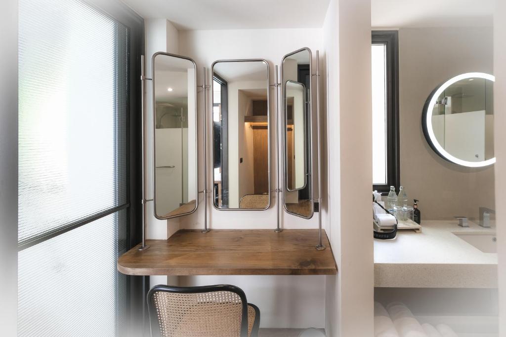 查汶Baan Haad Ngam Boutique Resort的浴室的木架上设有四面镜子