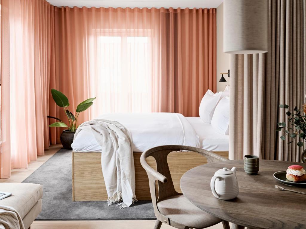 奥胡斯Aura Apartment Hotel的酒店客房配有一张床铺和一张桌子。