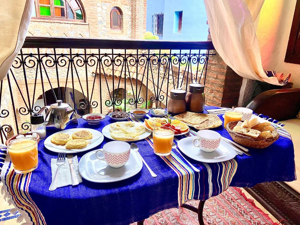 舍夫沙万里亚德戛纳塔庭院旅馆的一张蓝色桌子,上面有早餐食品和饮料