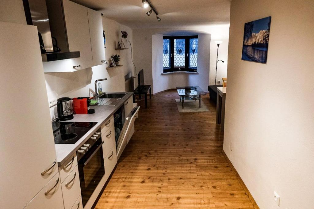 拉滕堡Ferienwohnung Martin的厨房铺有木地板,配有白色的柜台。