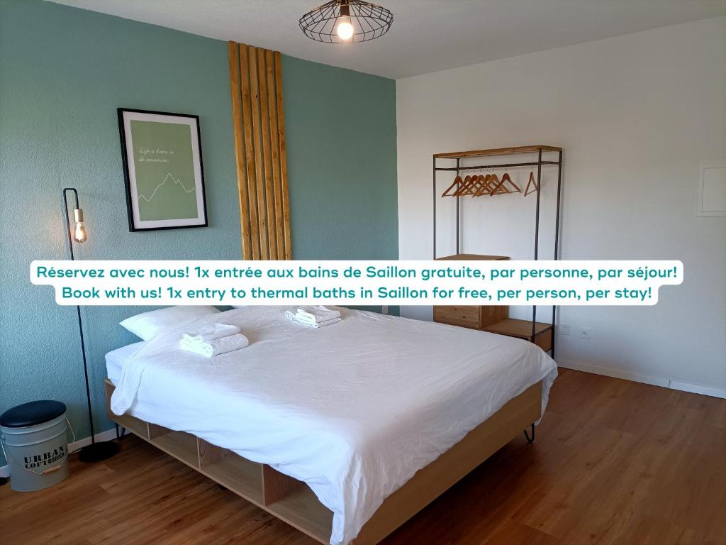 锡永Studio lumineux bien placé en ville de Sion的一间卧室配有一张带白色床单的床和墙上的绘画。