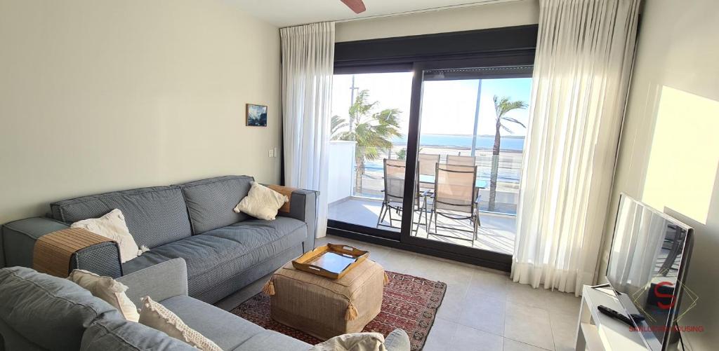 桑卢卡尔-德巴拉梅达Arenas de Doñana amplio apartamento frente del mar的带沙发的客厅,享有海景