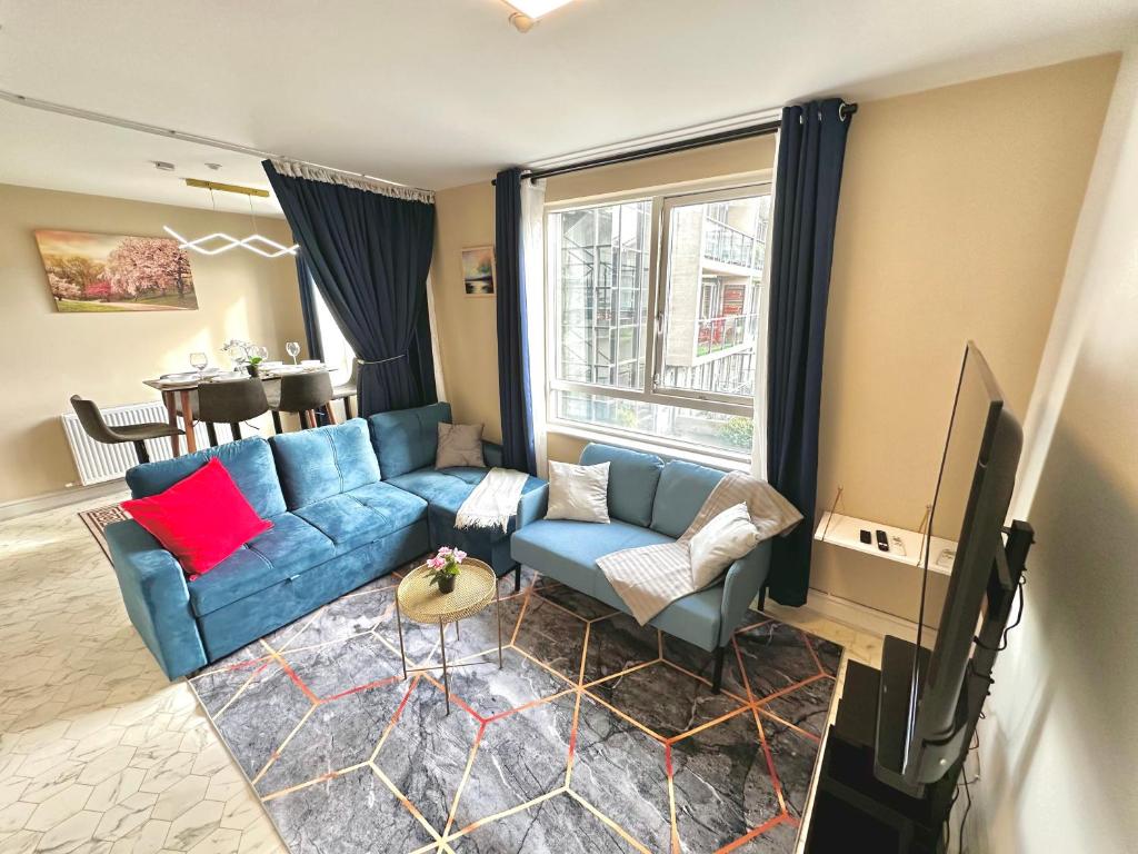 都柏林Modern 2Bedroom Oasis near Dublin city centre & Airport的客厅配有蓝色的沙发和电视