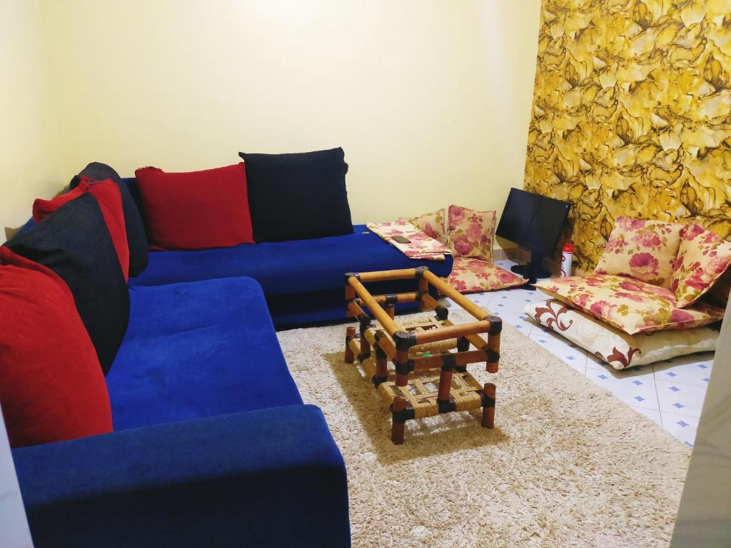 MasenoGill's Crib的客厅配有蓝色的沙发和椅子