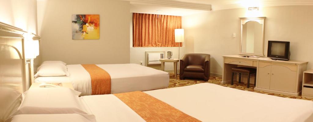 马尼拉海滨大厦酒店的酒店客房设有两张床和电视。