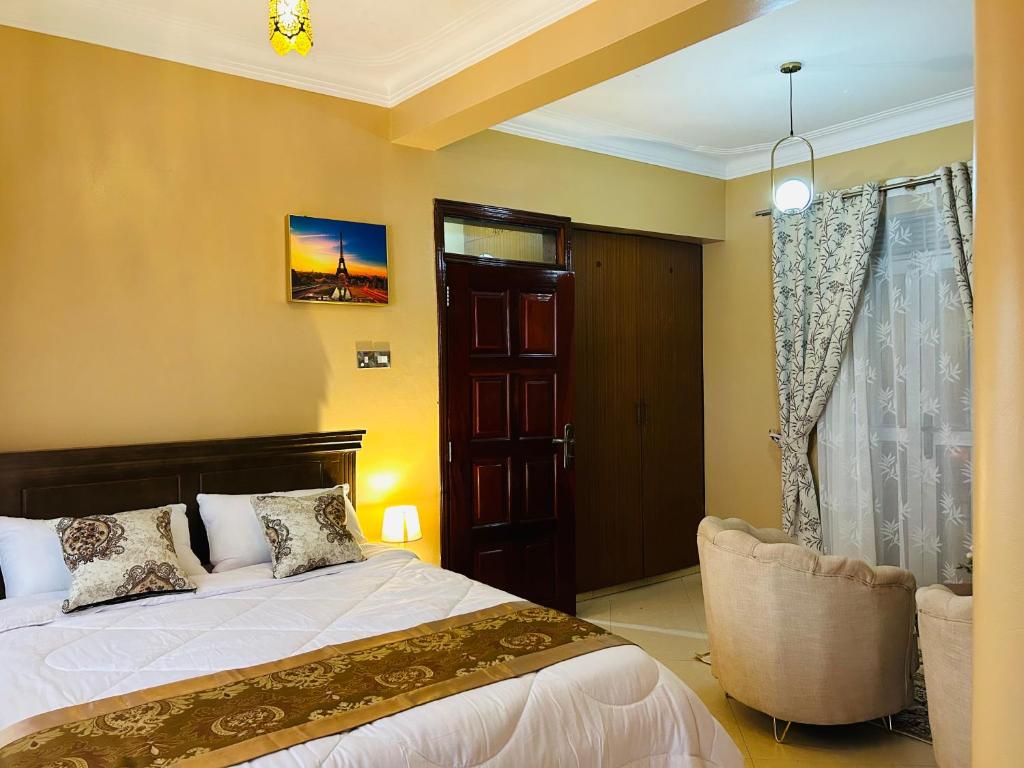 坎帕拉Casa Mia BnB的卧室配有床、椅子和窗户。