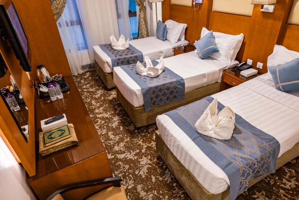 麦地那左瓦尔国际酒店的酒店客房设有三张床和电视。