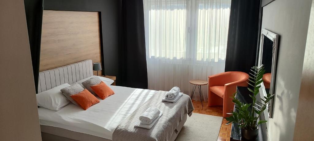 维舍格勒Apartman Minja的一间卧室配有带橙色枕头和椅子的床