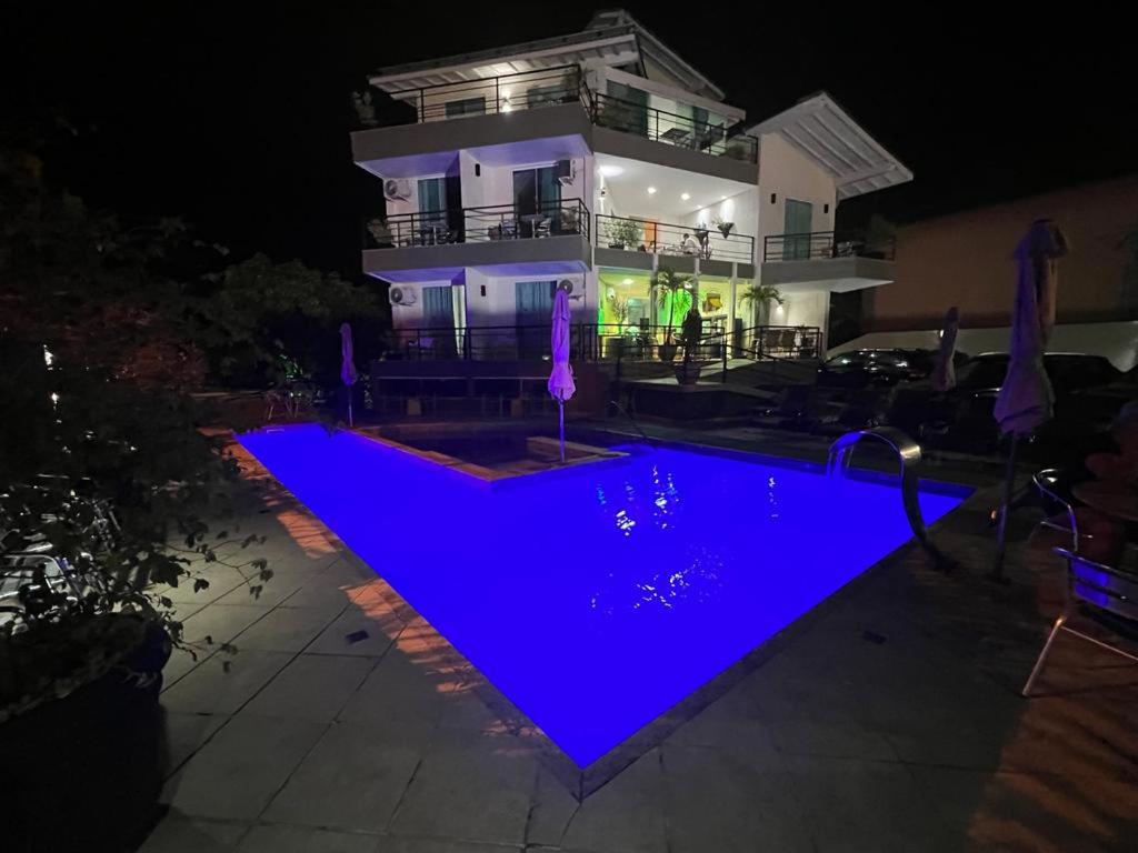 尼泰罗伊Camboinhas Beach Pousada的一座晚上设有游泳池的房子