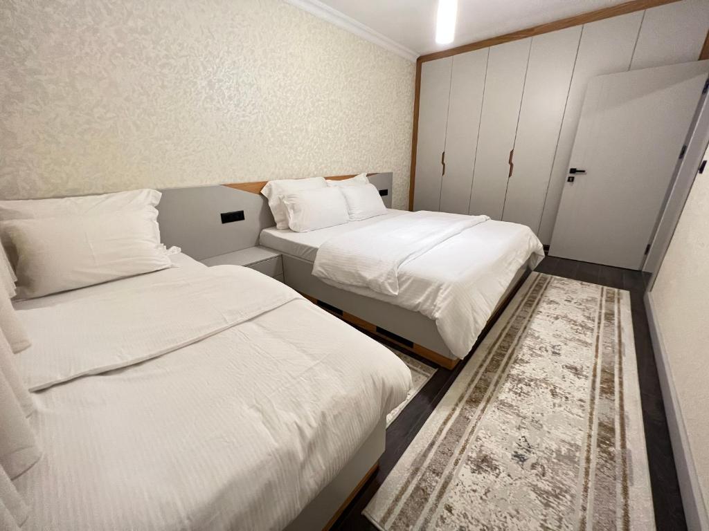 Apartament Koha的小客房内的两张床,配有白色床单