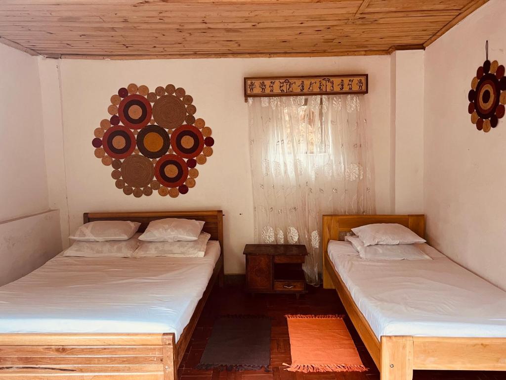 AmbositraLa Sirena Ambositra的一间设有两张床的客房和墙上的镜子