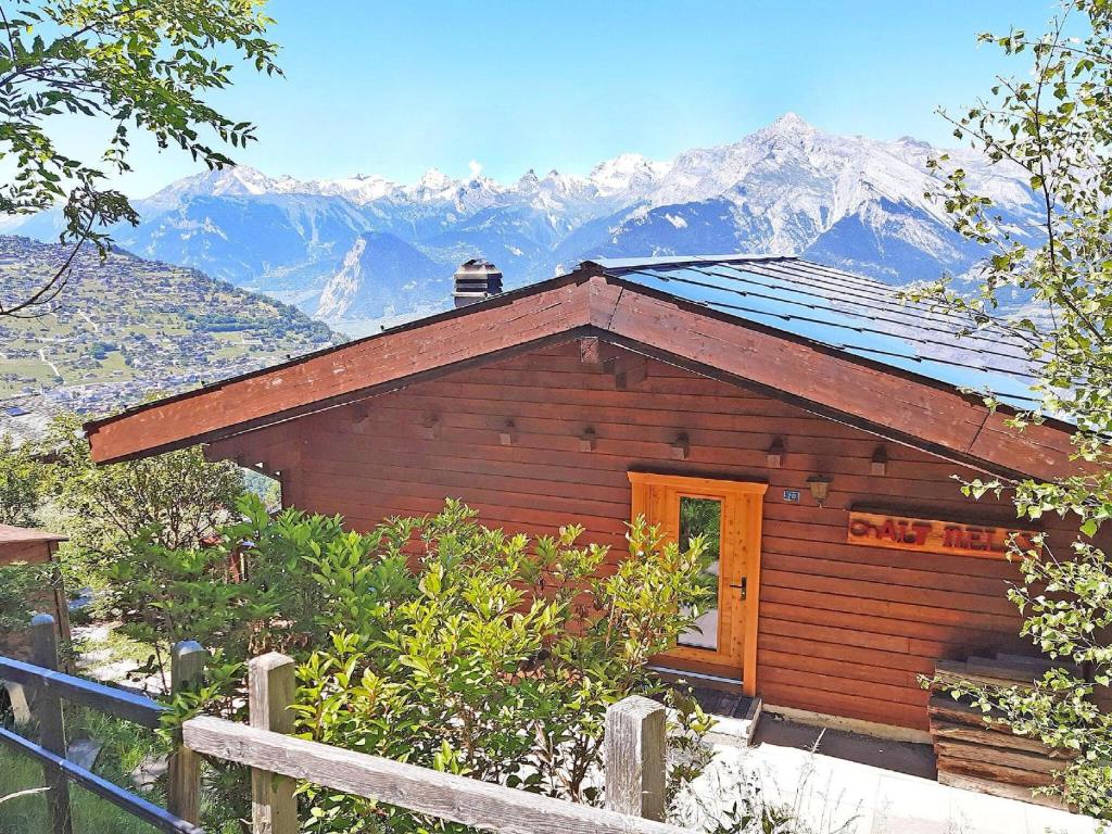 韦松纳chalet for 6 people with views of Veysonnaz的小屋的背景是一座小木屋,享有山景。